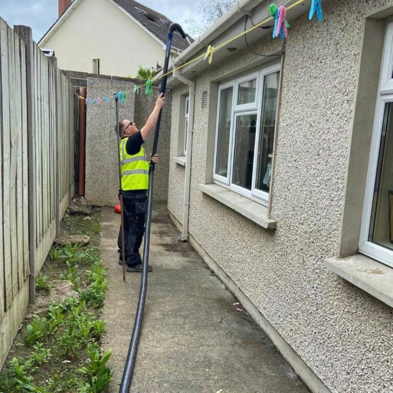 Tony Murphy cleaning the gutter with the maintenance crew vest